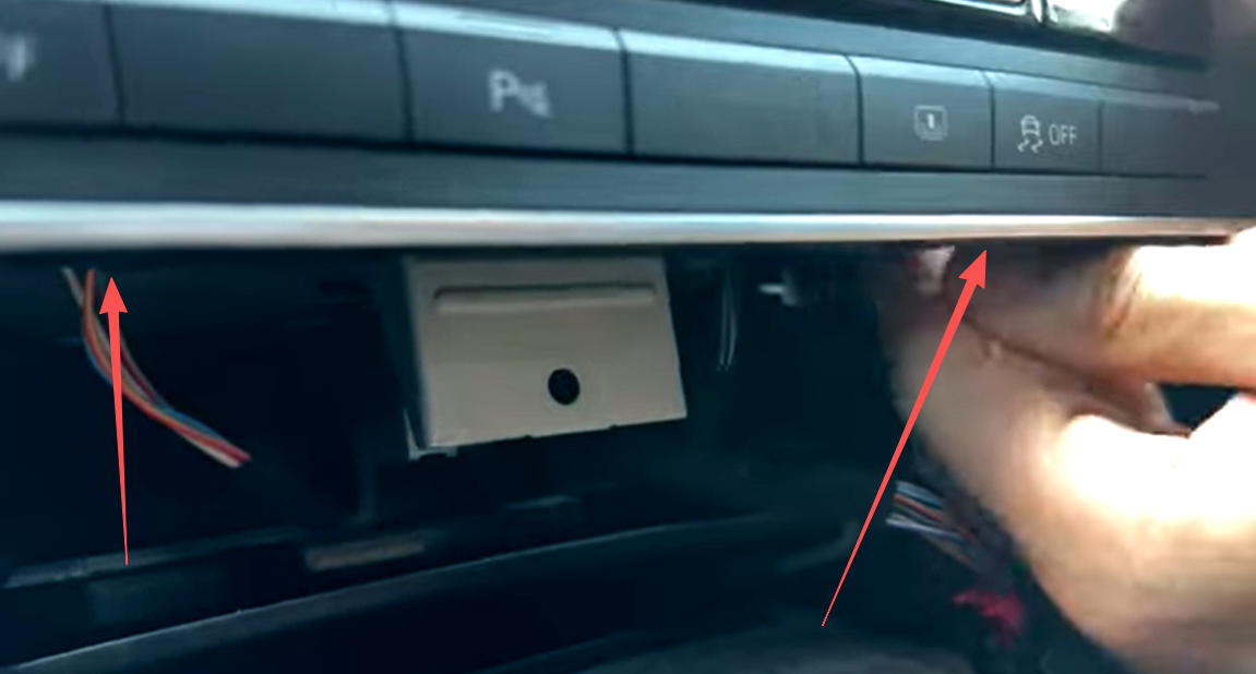 Trennen Sie die beiden Stecker unten links und rechts am MMI-Gerät.