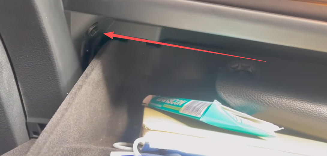 Schrauben Sie die Befestigungsschraube in der oberen linken Ecke des Handschuhfachs heraus.