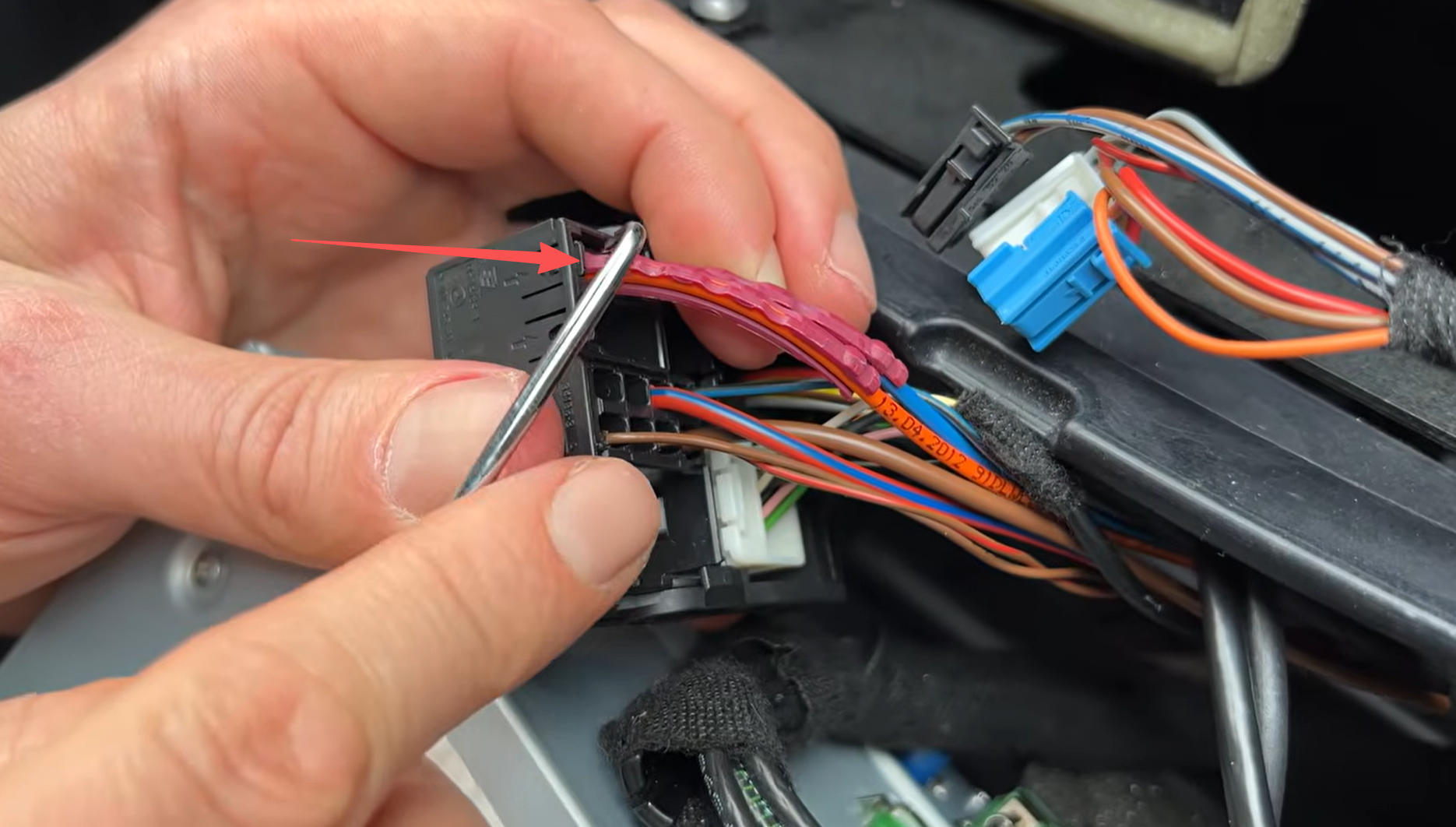 Orangefarbener MOST Lichtleiter im Mercedes CLS Stromstecker