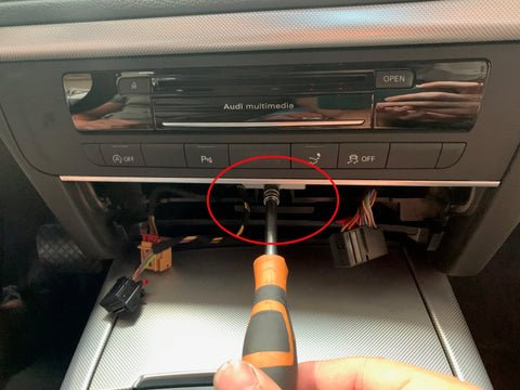 Torx-Schrauben der Audi A6/A7 MMI-Einheit werden mit Schraubendreher gelöst, um den Ausbau vorzubereiten